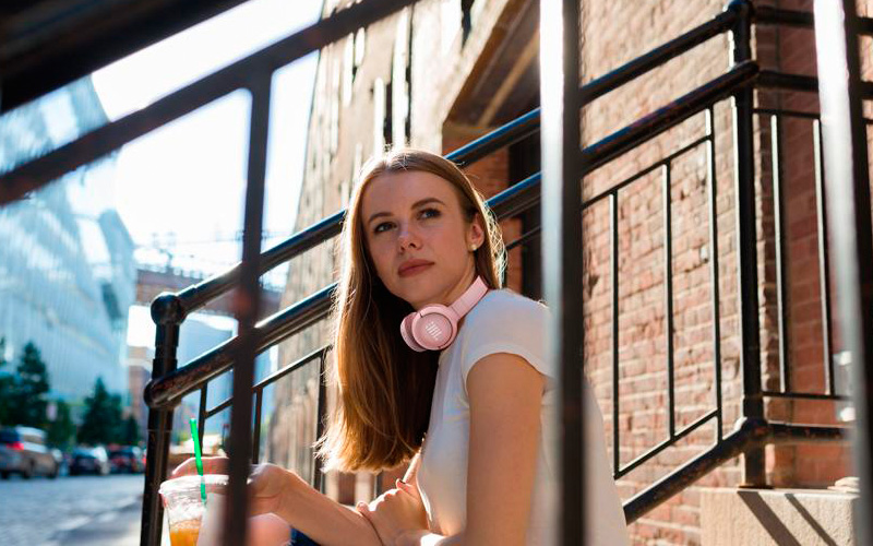 Růžová sluchátka TUNE 500BT nasazená na krku